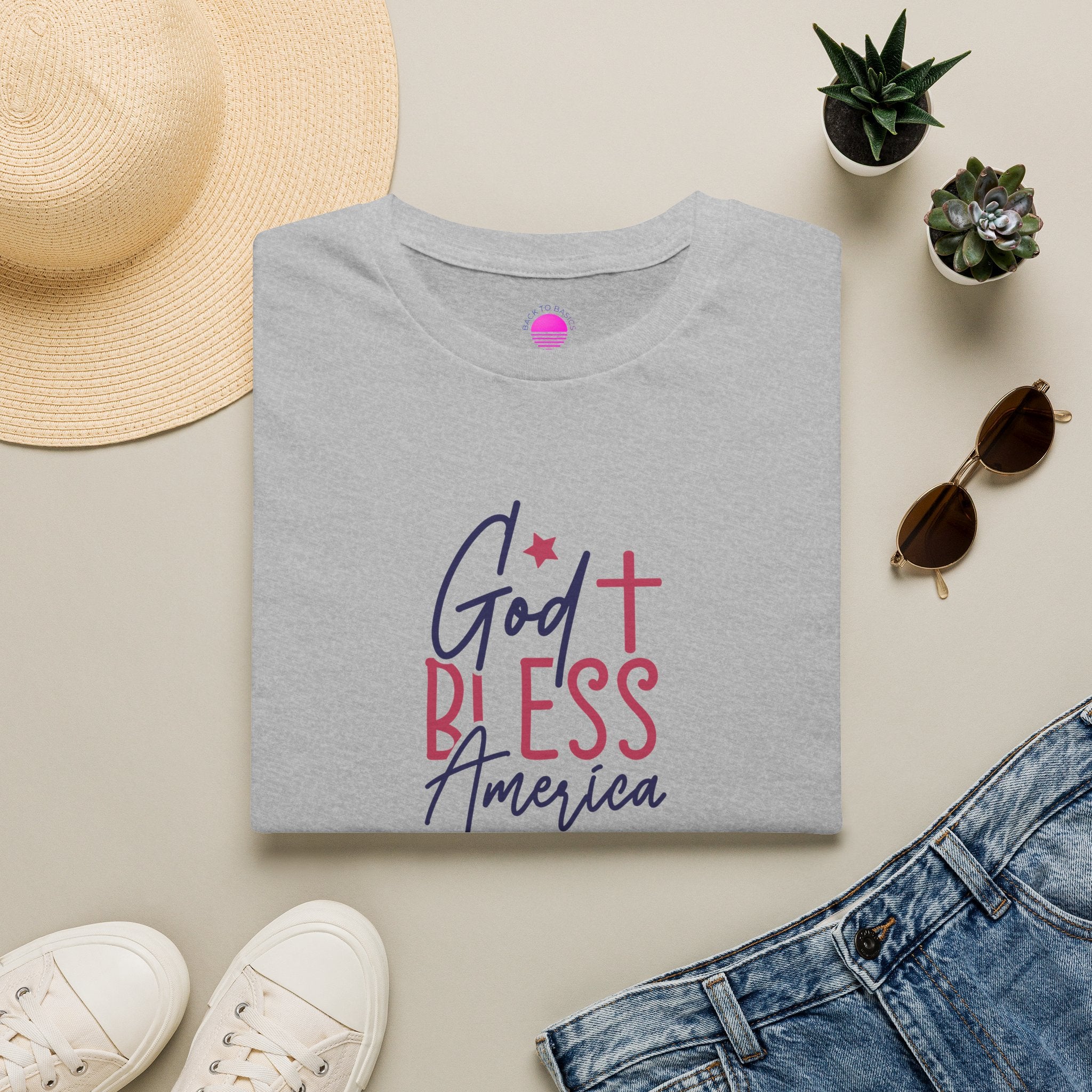 God Bless America Patriotic Christian T-Shirt with Cross displayed with sunglasses and a hat.