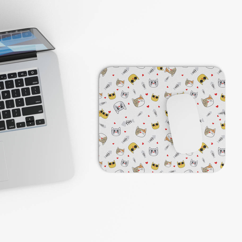 Cat-themed mouse pad with playful cat illustrations beside a laptop on a white background.