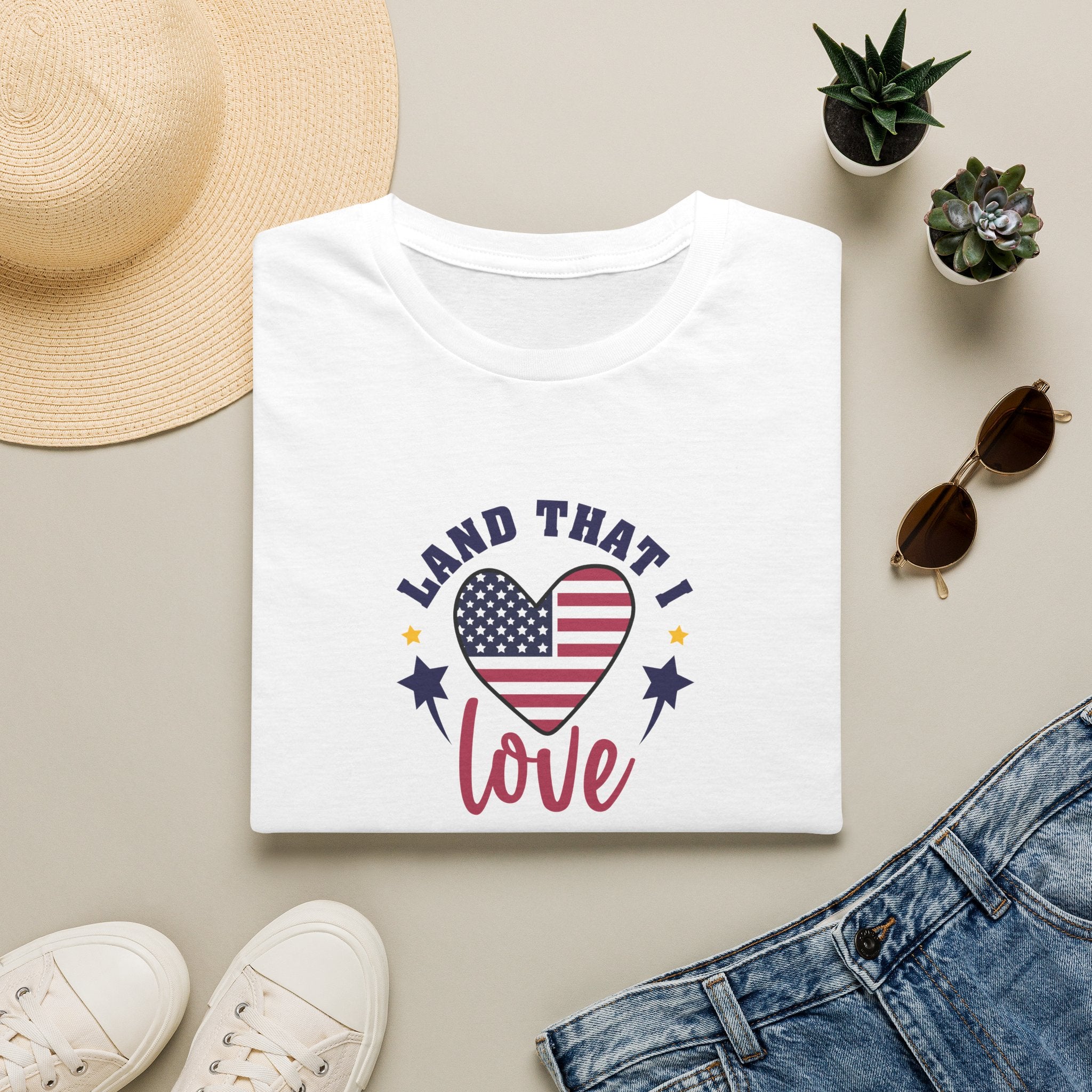 Land That I Love patriotic t-shirt with American flag displayed on a white tee, styled with denim and accessories.