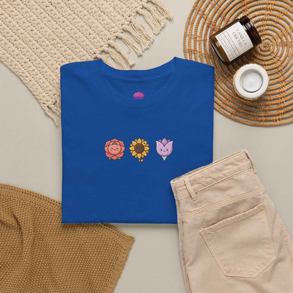 Floral back to school tee in blue with colorful flower designs on the front, styled with beige pants.
